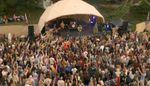 Gathering around the Soul Revolution Festival fire, goers playing drums and adding wood to fire, festival crowd surrounding the space.
