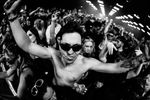 Festivalgoers dancing together in a tightly packed crowd.