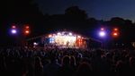Crowd watching a brightly lit band perform on the main stage at night at Mostly Jazz Funk & Soul Festival.
