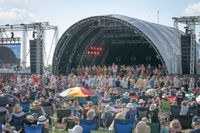 Main stage at Shrewsbury Folk Festival, brightly coloured stage lights with folk musicians performing.