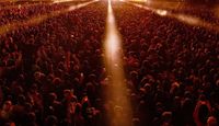 Beams of stage lights over large crowd at Field Day Festival.
