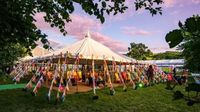 Under a marquee during the Hay Festival, bunting covering the guy ropes.