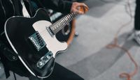 Person holding an electric guitar.