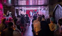 Audience watching a stand-up comedy performance in an intimate basement venue during the Reading Indie Comedy Festival.