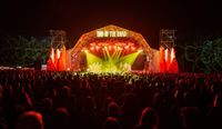 End Of The Road Festival main stage at night, filled with stage lights and crowd in silhouette.