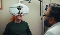 Still image from the short film titled 'The Test', it shows an image of a man receiving an eye examination from an optometrist.