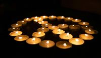 Circle of candles, in a peace sign formation.