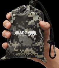 Person holding Bearz waterproof picnic blanket in its carry bag.