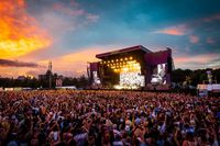 View of the main stage at TRNSMT Festival at sunset, with large crowd in the foreground.