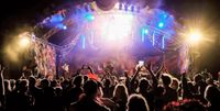 Image of the Big Love Festival stage, the stage is well lit with an enthusiastic crowd in the foreground.