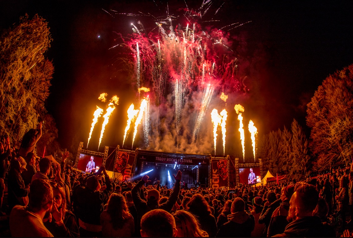 Crowd enjoying a spectacular fireworks and pyrotechnics show at night during Teddy Rocks Festival.