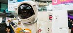 Person in an astronaut suit reading a Norwich Science Festival programme inside The Forum