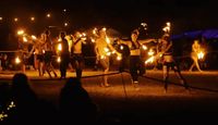 Festival procession at night, community of festival goers walking with lights.