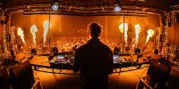 DJ facing an exuberant crowd with fiery stage pyrotechnics at Balter Festival.