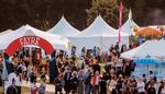 Outside view of HowTheLightGetsIn Festival location, showing marquees and crowd mingling.