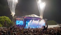 Truck Festival main stage at night with fireworks bursting overhead and a crowd of fans celebrating in front of the stage.
