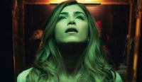 A film still image from Bone Lake, beautiful woman looking up into the light.