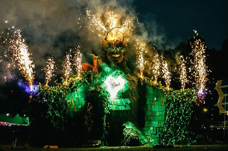 Image of huge Green Man sculpture with fireworks coming out of head and arms.