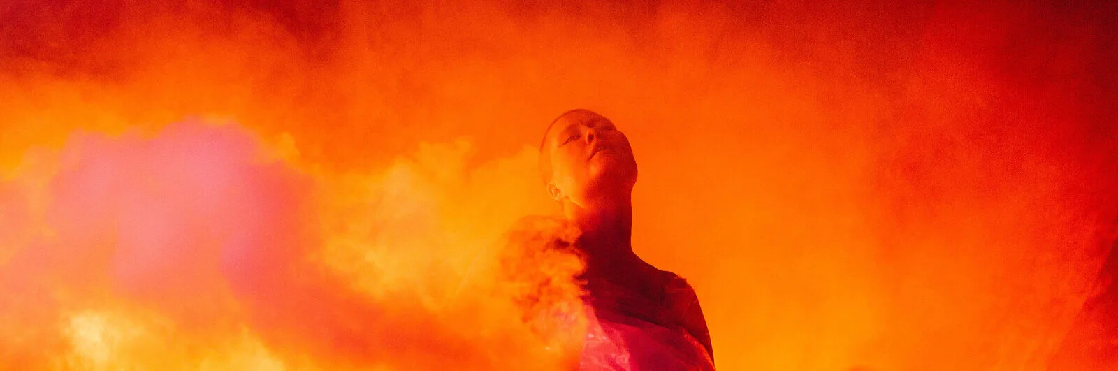 Shambala photo, Livia Rita in orange glow stage lighting with smoke effect, photo credit: George Harrison
