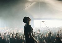 ArcTanGent performer, head back under a large top marquee.