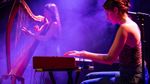 Members of Léda perform on harp and keyboard under purple stage lighting. Photograph: Sean Purser.