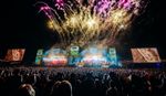 Fireworks above the main stage at CarFest Festival, with huge crowd in the foreground.