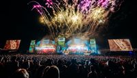 Fireworks above the main stage at CarFest Festival, with huge crowd in the foreground.
