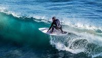 Surf rider performing floater on a wave.